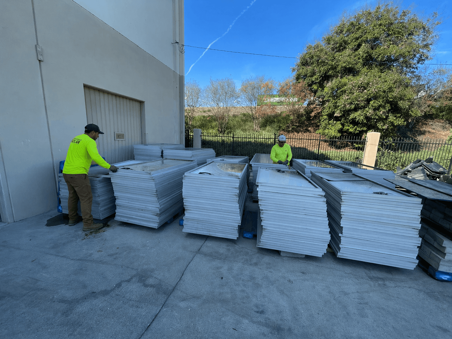 Repurpose Solar crew palletizing decommissioned panels at a warehouse loading dock